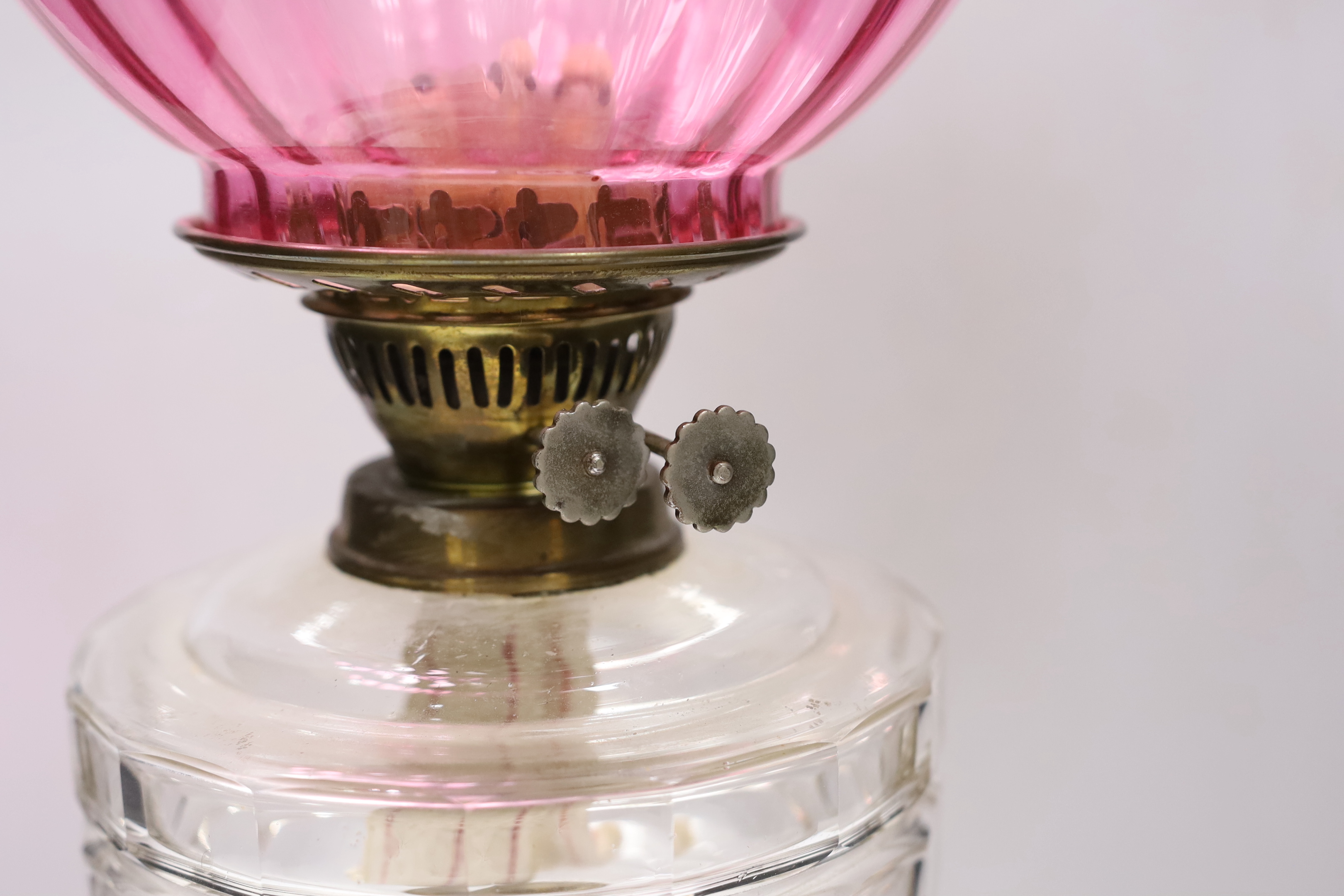 A Victorian brass based oil lamp, with cranberry glass shade, 58cm high